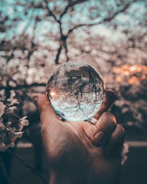Photo of a hand holding a glass orb, representing how to turn an idea into a story.