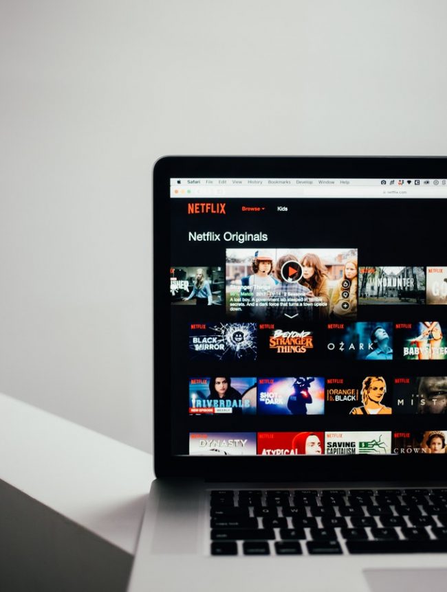 Photo of a laptop screen featuring Netflix TV shows and movies