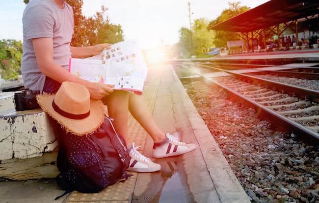 Girl sitting waiting for her train | Author Joan K. Lacy provides travel tips!