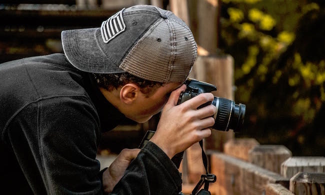 A photographer looks through his lens, snapping photos at a book cover photo shoot.